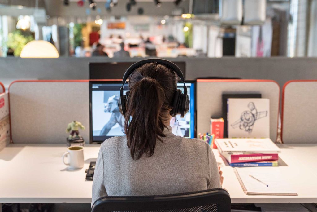 visuel d'une personne à son bureau devant son ordinateur