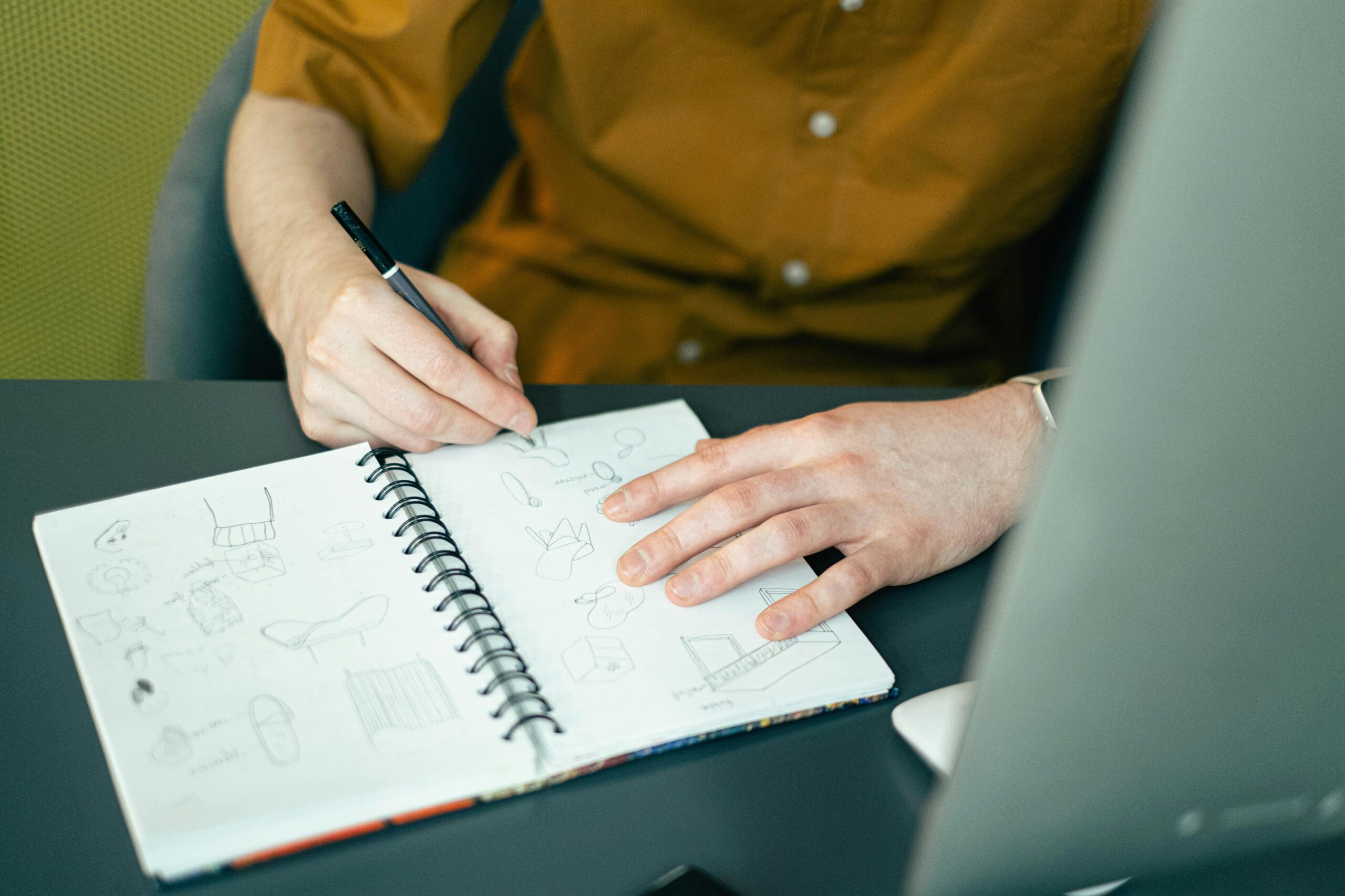 Designer sketchant des idées dans un carnet — phase de conception d'une expérience immersive